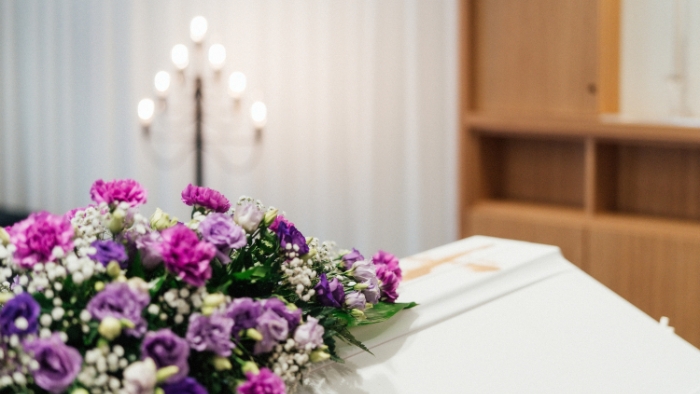 Närbild av minnesblommor på kistan i kapellet Aeternitas.
