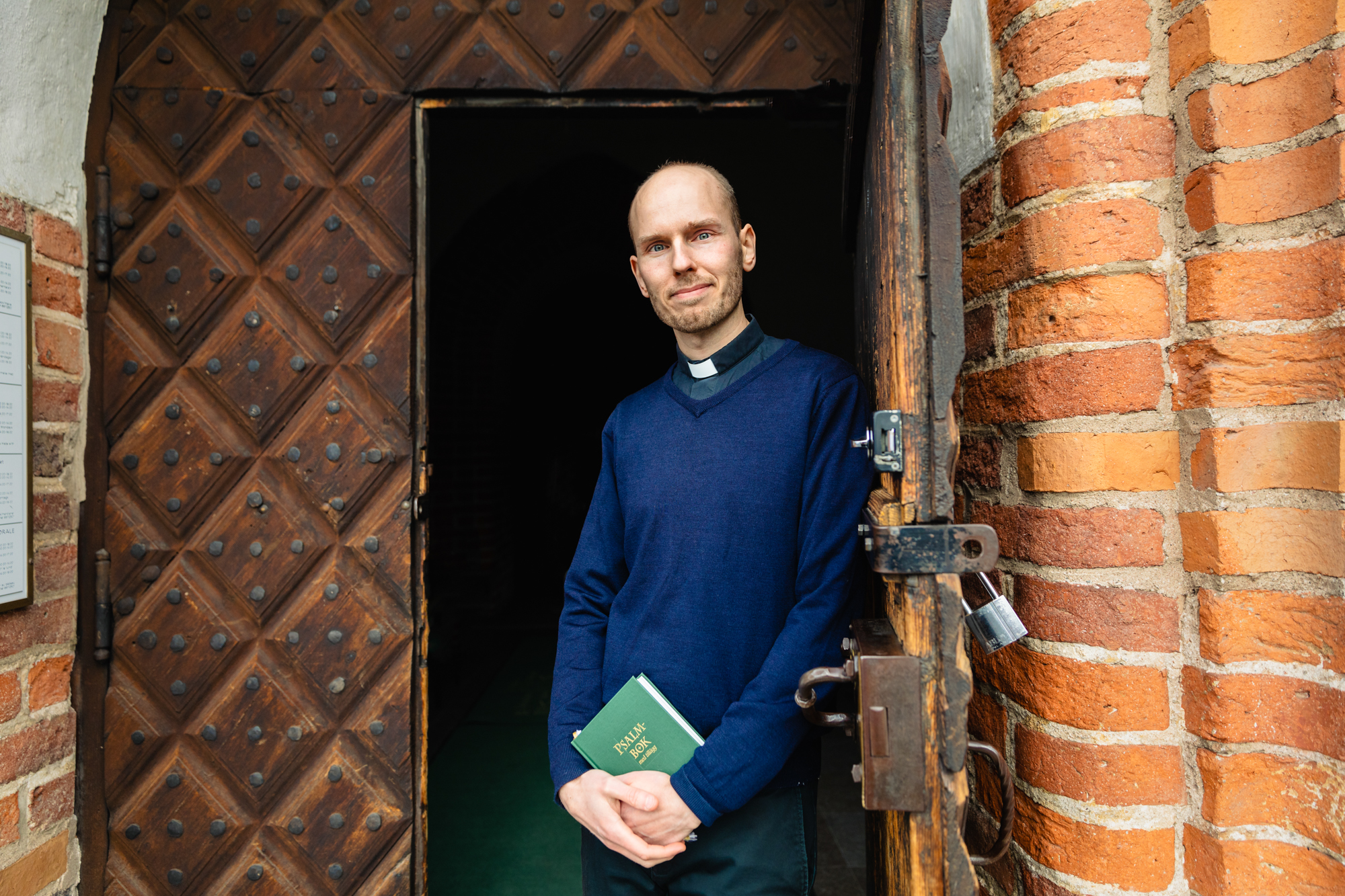 Präst i kyrkdörrens öppning.