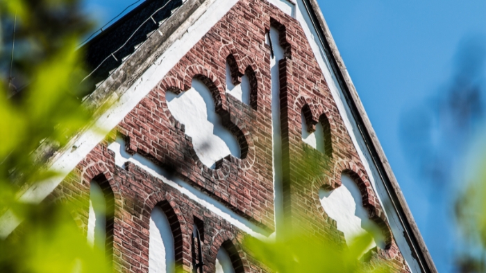 Gavelfrontonen på Borgå domkyrka fotograferad genom vårkvistar.