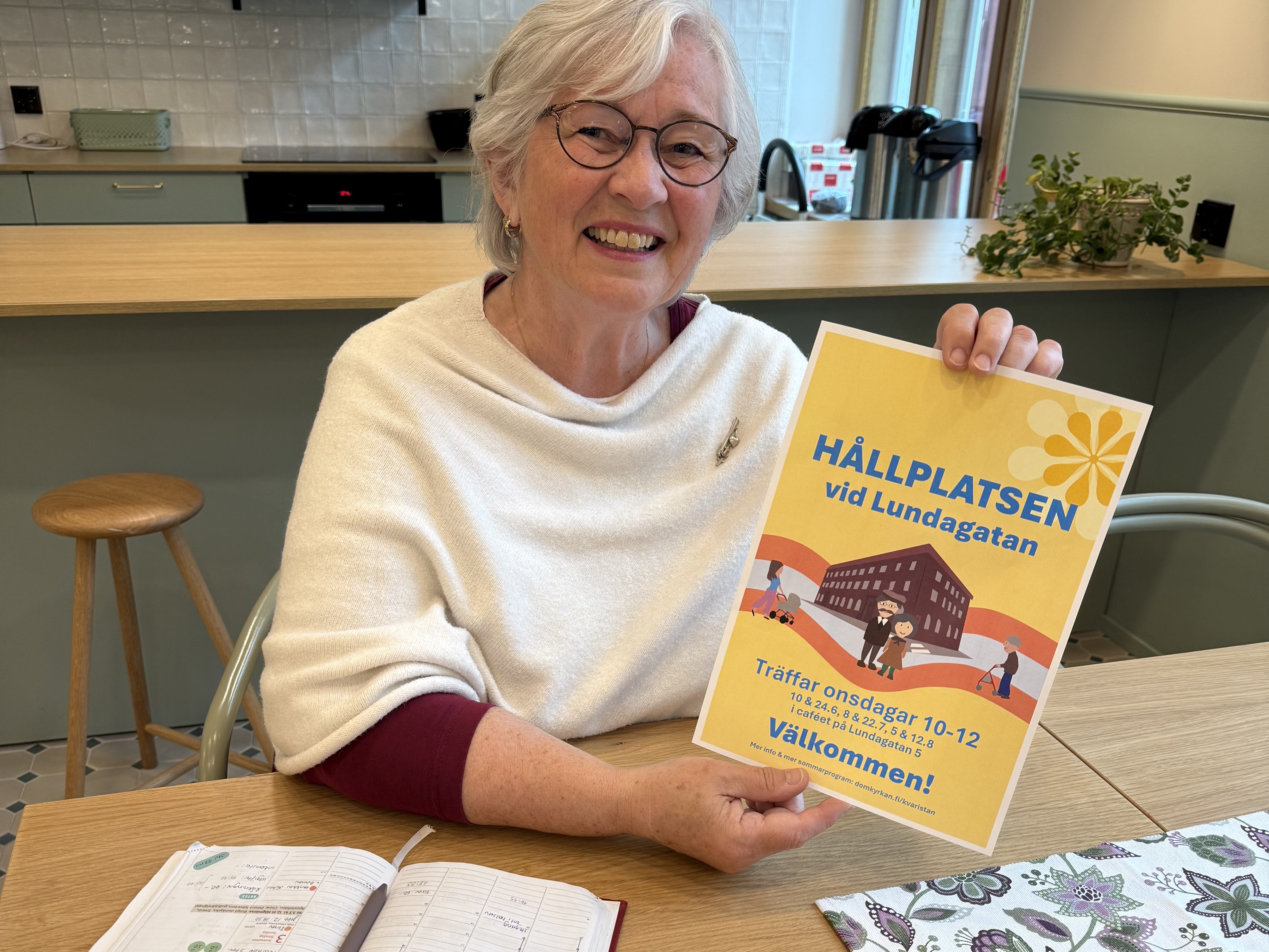 Kvinna håller upp skylt med texten Hållplatsen på Lundagatan.