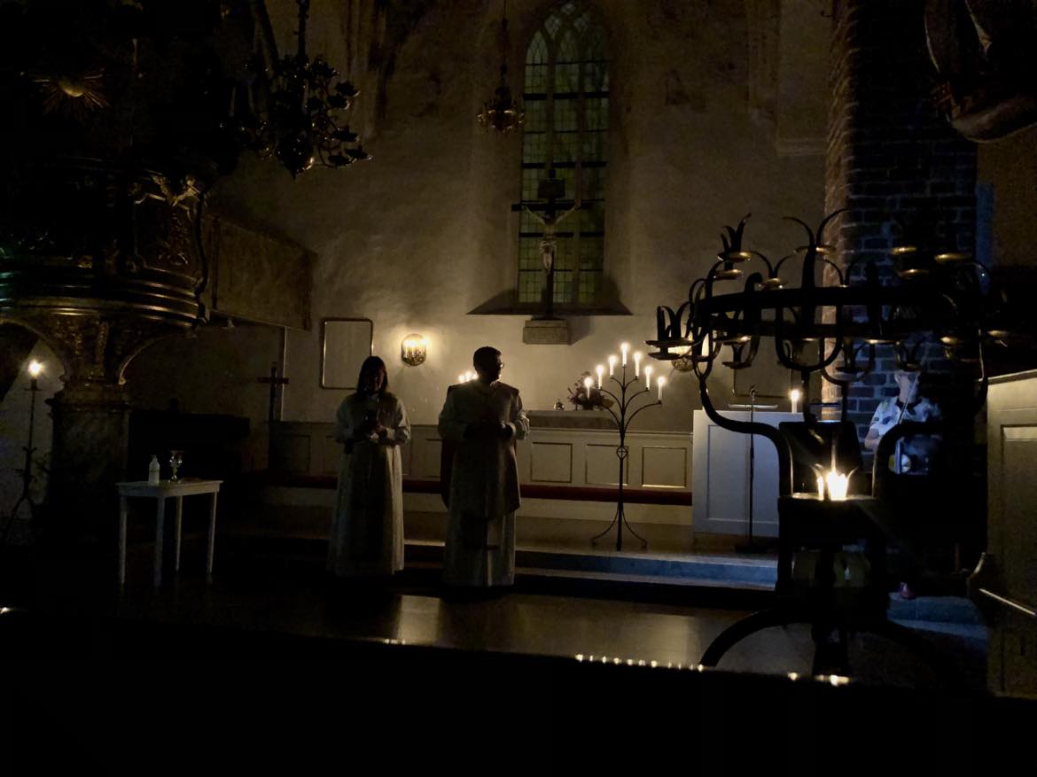 Kyrkan mörklagd med levande ljus