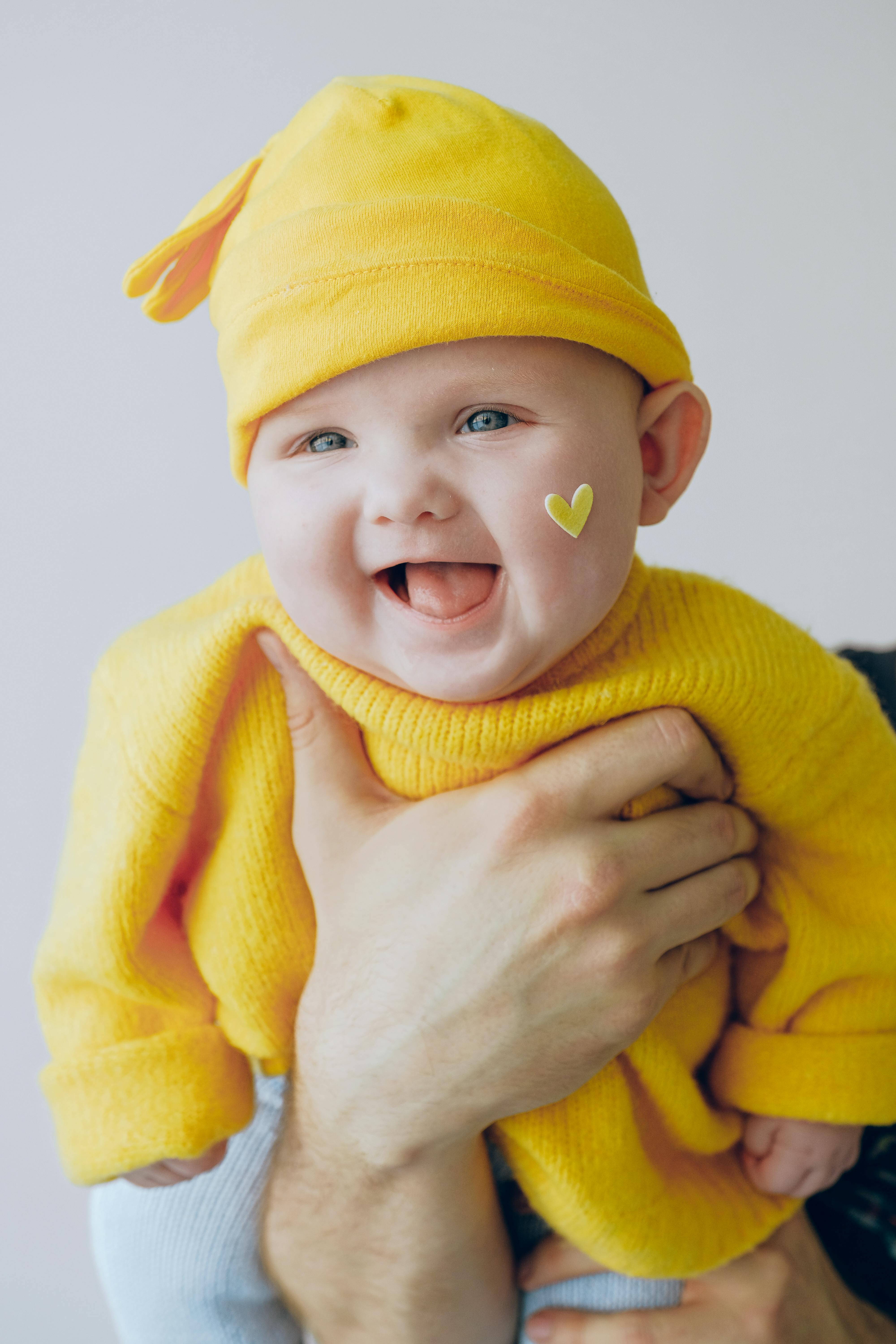 Glad baby med gula kläder