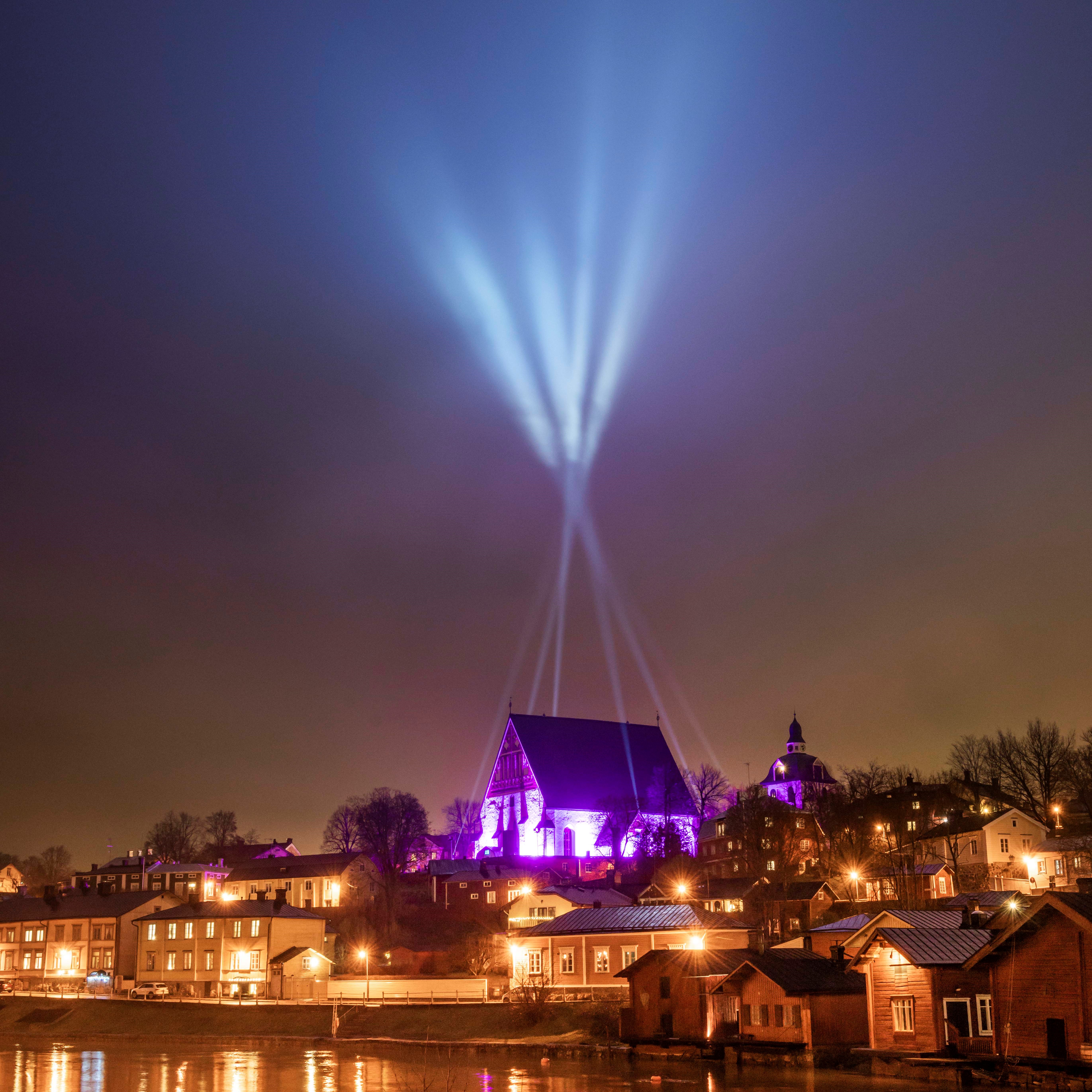 Kvällsvy över Borgå, stor blått ljus lyser kring kyrkan.