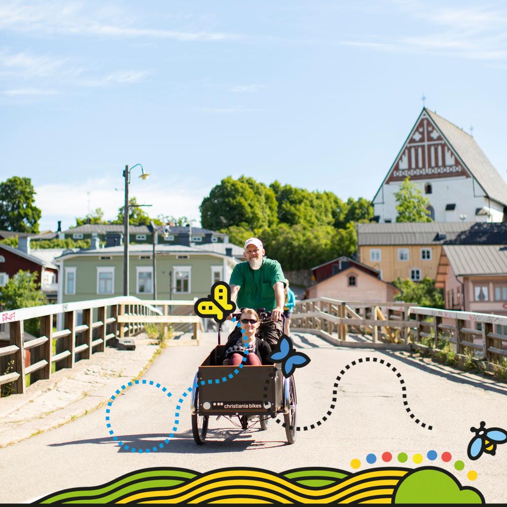 Somrig dag, två personer på en cykel med framlåda, Borgå domkyrka i bakgrunden.