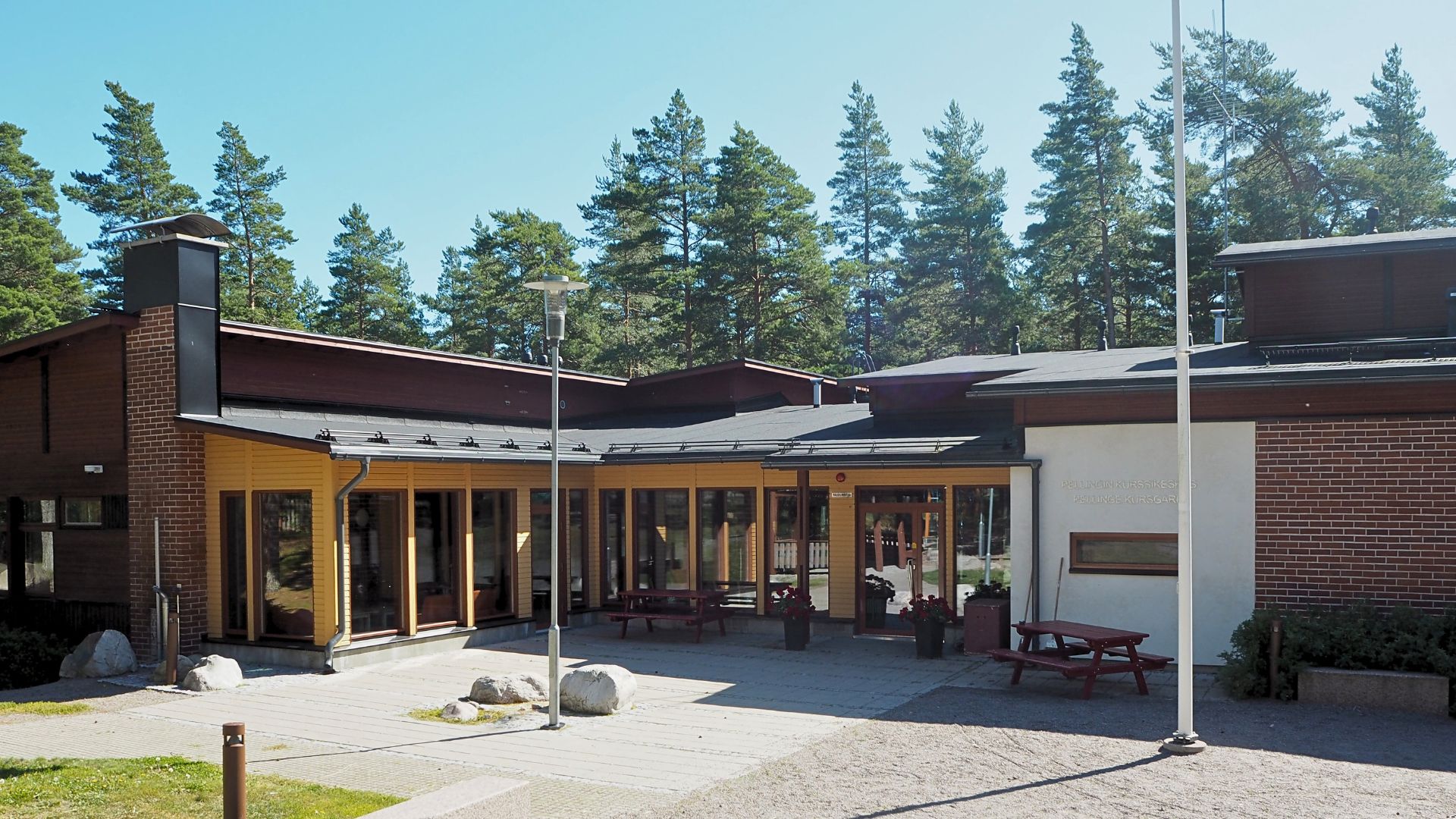 Stort hus av tegel, lägergård, infart.