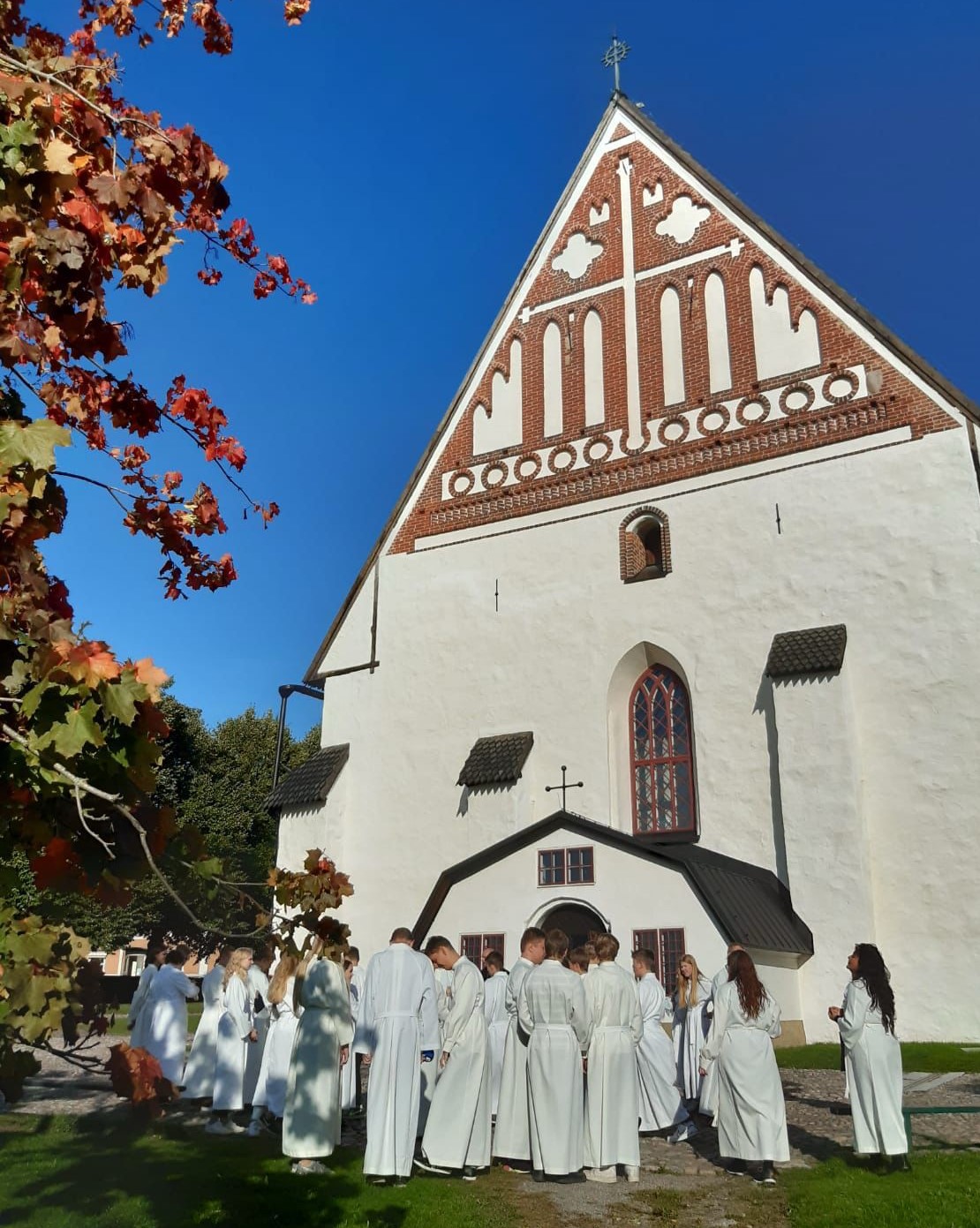 Bild på kyrkan med konfirmander i albor